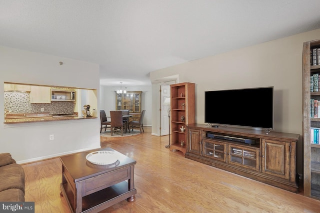 living area with light wood finished floors and a chandelier