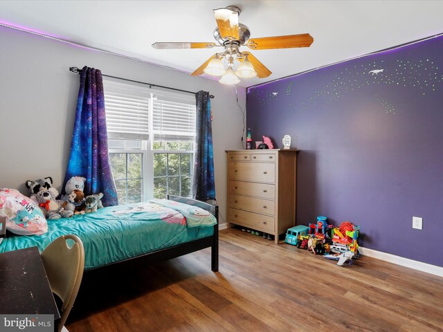 bedroom with wood finished floors, baseboards, and ceiling fan