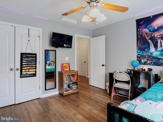 bedroom featuring wood finished floors, a ceiling fan, and baseboards