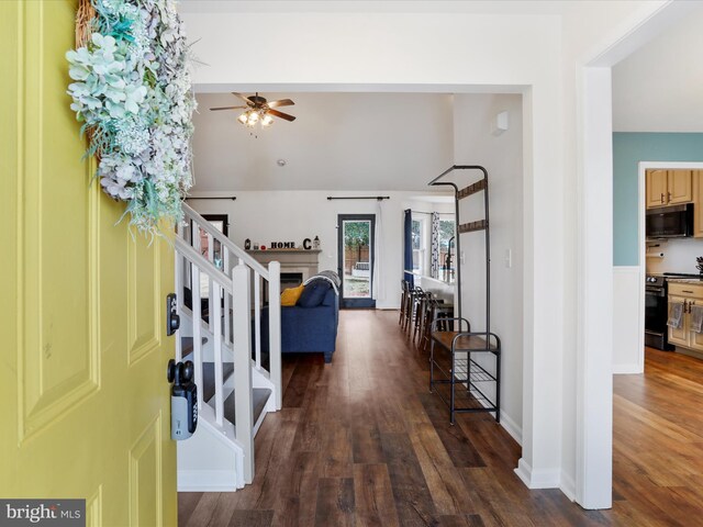 foyer entrance featuring ceiling fan, dark wood finished floors, stairs, and baseboards