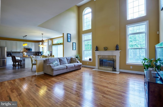 28 Autumnwood Ln, Mount Laurel, NJ 08054 - living room with hardwood / wood-style flooring, a towering ceiling, a premium fireplace, and baseboards