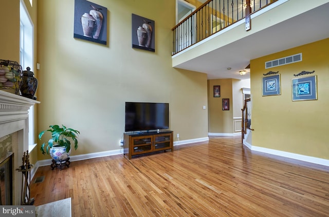 28 Autumnwood Ln, Mount Laurel, NJ 08054 - living room featuring a premium fireplace, wood finished floors, a towering ceiling, and baseboards