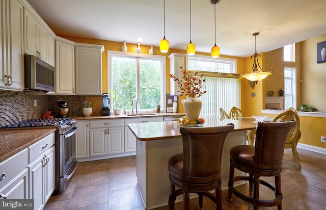 28 Autumnwood Ln, Mount Laurel, NJ 08054 - kitchen with appliances with stainless steel finishes, a sink, decorative backsplash, a kitchen bar, and a center island