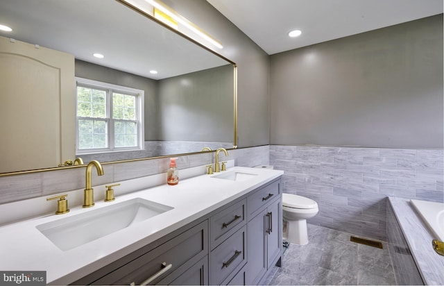 28 Autumnwood Ln, Mount Laurel, NJ 08054 - full bathroom with tile walls, toilet, double vanity, tiled tub, and wainscoting