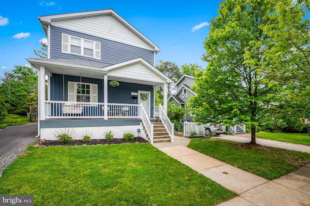 view of front of property with covered porch, a front yard, board and batten siding, and a shingled roof