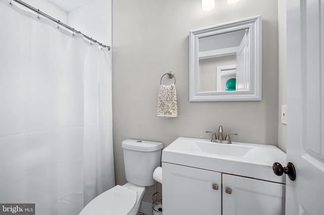 bathroom featuring toilet, vanity, and a shower with curtain