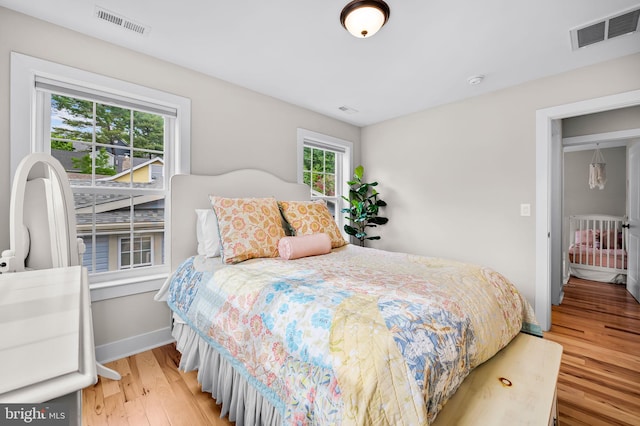 bedroom featuring light wood finished floors and baseboards