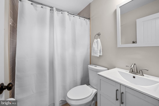 bathroom with toilet, vanity, and a shower with curtain