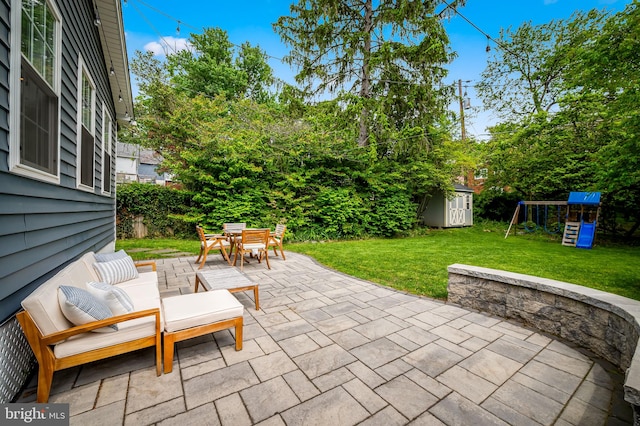 view of patio with outdoor dining area, a shed, a playground, and an outdoor structure