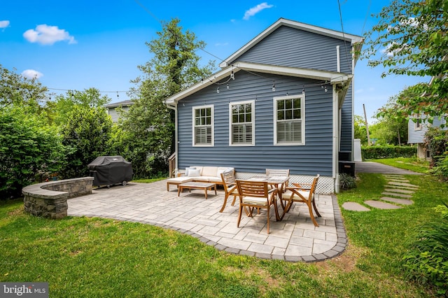 rear view of house with a patio, a yard, and an outdoor living space