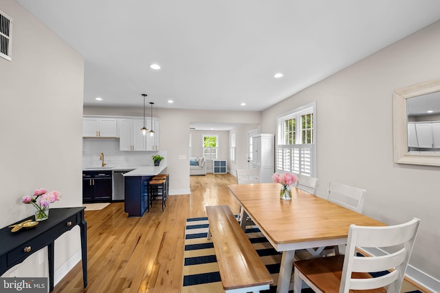 dining space featuring light wood-style floors, baseboards, and recessed lighting