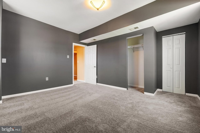 unfurnished bedroom with baseboards, visible vents, and carpet floors