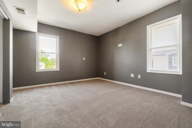 unfurnished room featuring baseboards, carpet flooring, and visible vents