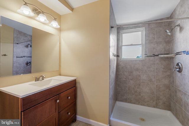 full bath featuring vanity and tiled shower
