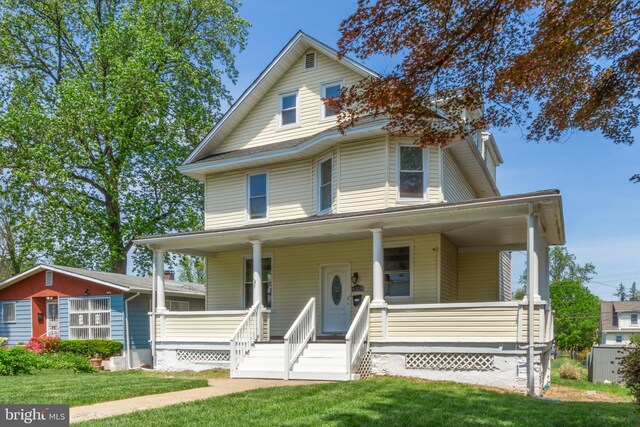 farmhouse inspired home featuring a porch and a front lawn