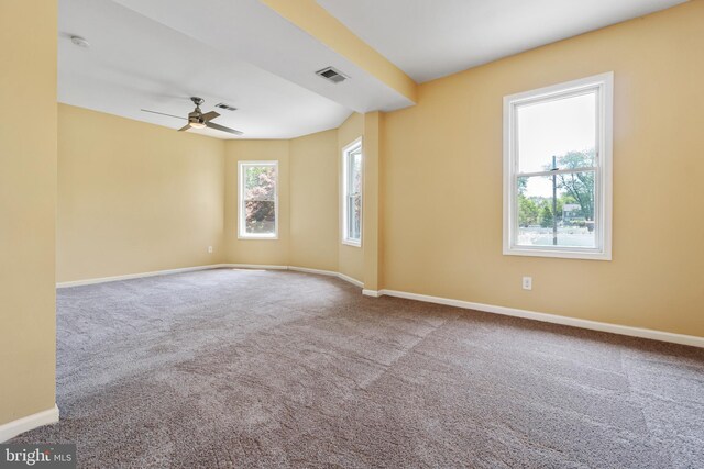 spare room featuring carpet flooring, visible vents, baseboards, and a ceiling fan
