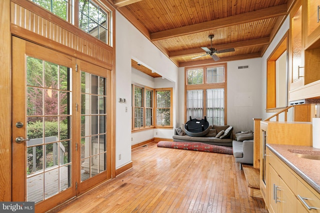 sunroom with french doors, plenty of natural light, and beamed ceiling