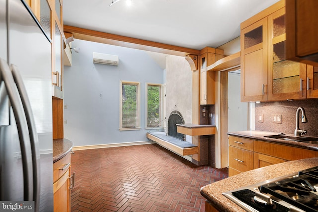 kitchen featuring stainless steel appliances, a sink, a wall unit AC, brick flooring, and tasteful backsplash