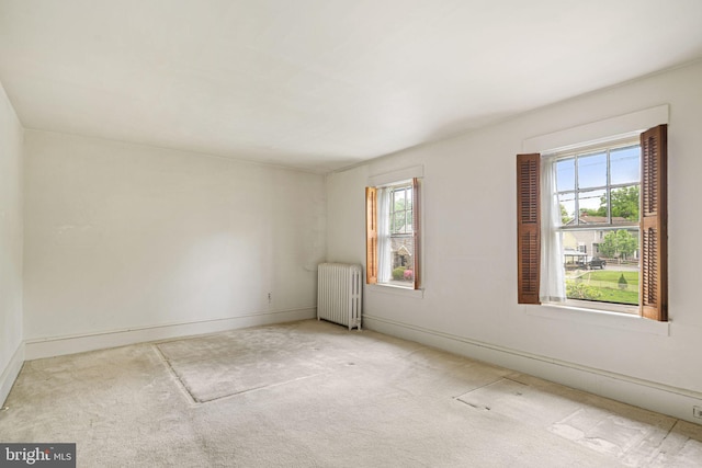 unfurnished room with radiator heating unit, carpet flooring, and baseboards