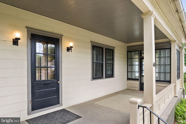 entrance to property featuring covered porch and concrete block siding