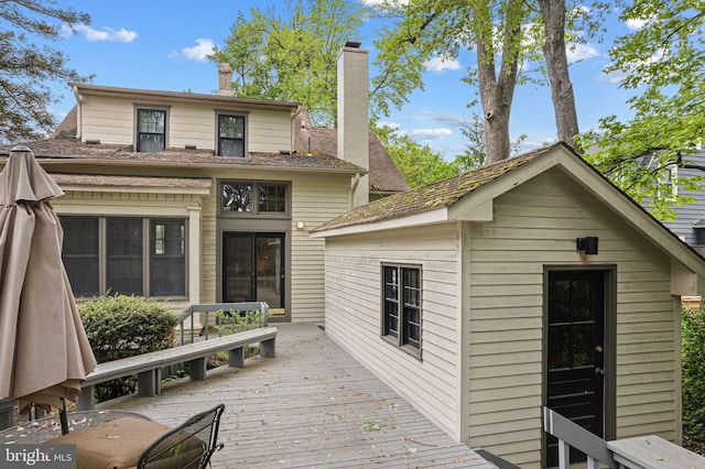 rear view of house with a chimney and a deck