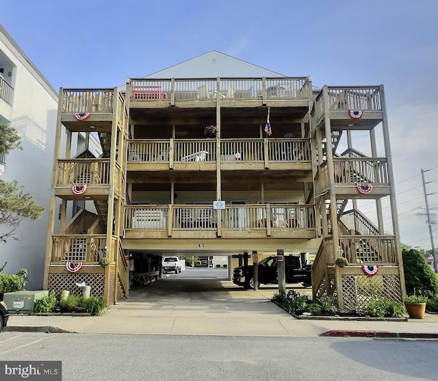 17 143rd St Unit 302, Ocean City, MD 21842 - view of building exterior featuring stairs, a carport, and concrete driveway