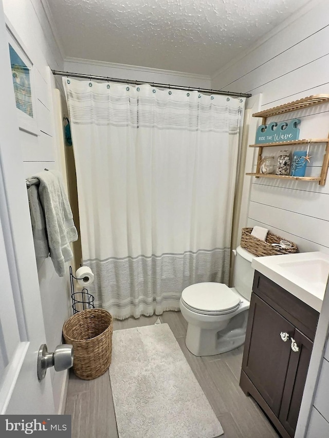 17 143rd St Unit 302, Ocean City, MD 21842 - bathroom with a textured ceiling, toilet, ornamental molding, vanity, and wood finished floors