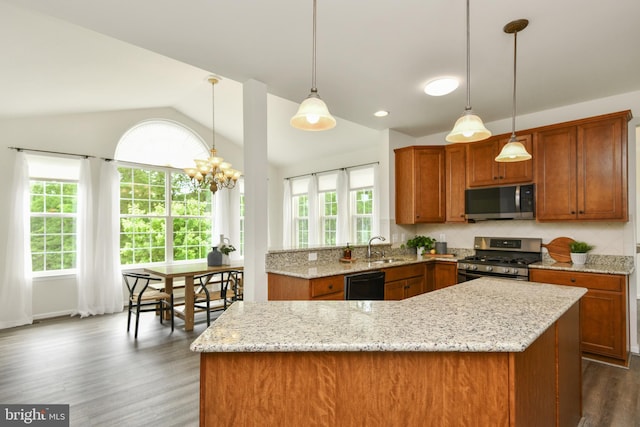 kitchen featuring stainless steel appliances, brown cabinetry, vaulted ceiling, healthy amount of natural light, and dark wood-style floors