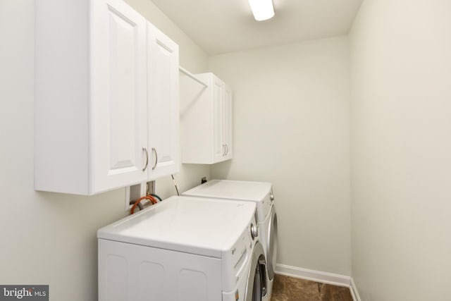 clothes washing area with cabinet space, independent washer and dryer, and baseboards