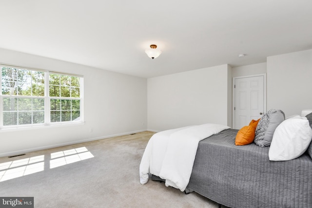 bedroom with light colored carpet and baseboards