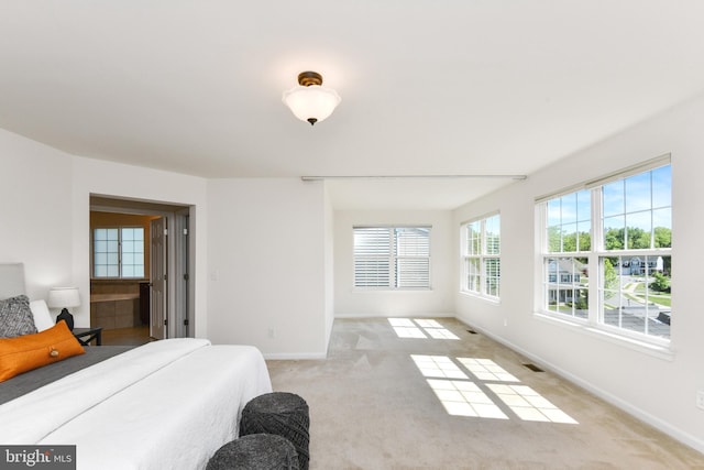 bedroom featuring light colored carpet and baseboards