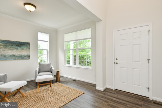foyer with crown molding, wood finished floors, and baseboards