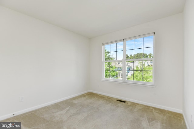 unfurnished room featuring baseboards and light carpet