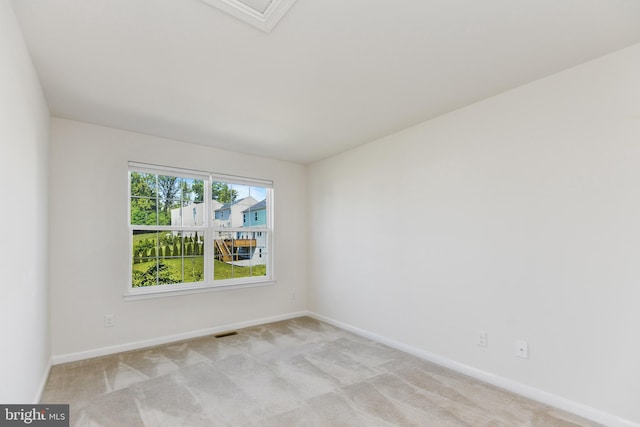 empty room featuring baseboards and carpet