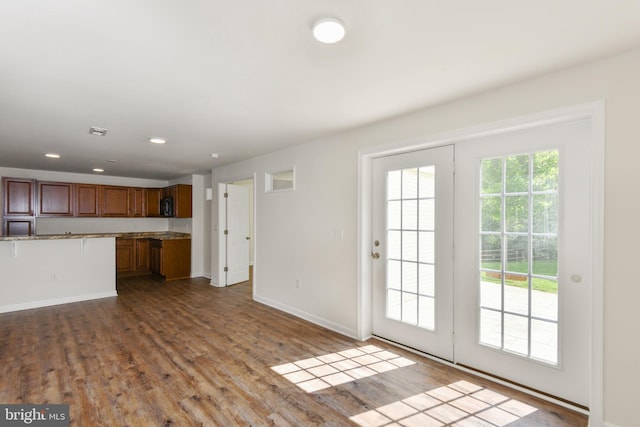 unfurnished living room featuring baseboards, dark wood-style flooring, and recessed lighting