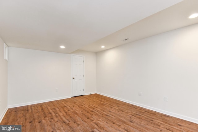 finished below grade area featuring wood finished floors, baseboards, and recessed lighting