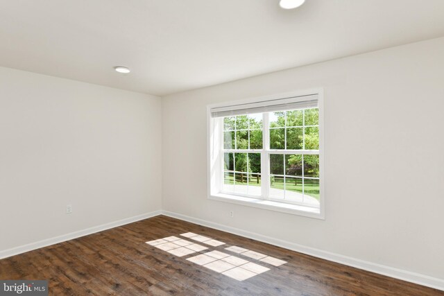 empty room featuring baseboards and wood finished floors