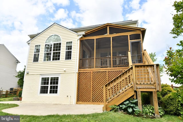 rear view of house with a patio area and a sunroom