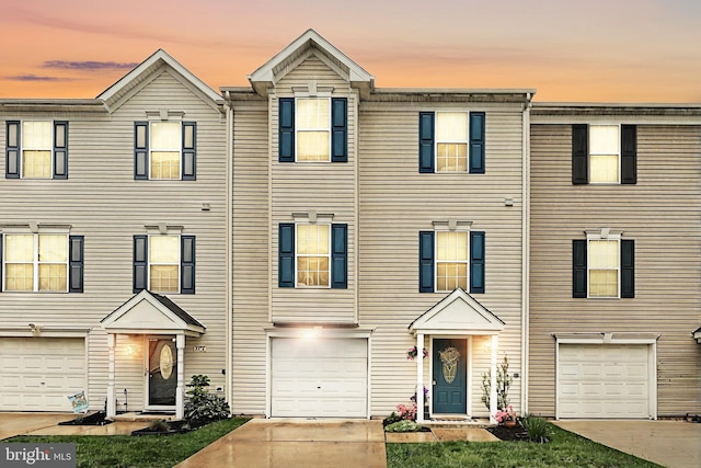 multi unit property with an attached garage and driveway