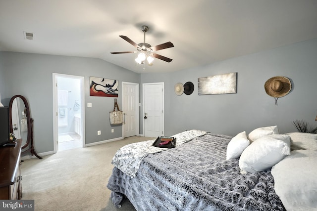 bedroom featuring light carpet, lofted ceiling, baseboards, ensuite bathroom, and a ceiling fan