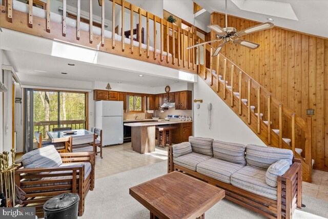 249 Hyland Dr, East Stroudsburg, PA 18301 - living area featuring wood walls, a skylight, light floors, stairway, and ceiling fan