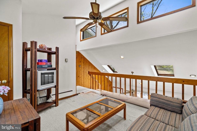 249 Hyland Dr, East Stroudsburg, PA 18301 - carpeted living area featuring ceiling fan, a skylight, a high ceiling, and wood walls