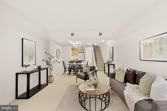 616 E St NW Unit 447, Washington, DC 20004 - living area featuring visible vents, stairway, crown molding, light carpet, and baseboards