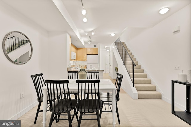 616 E St NW Unit 447, Washington, DC 20004 - dining space with track lighting, light carpet, baseboards, and stairs