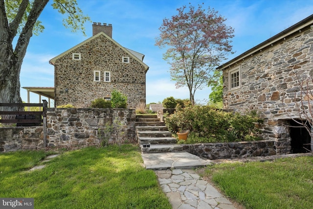 275 S Creek Rd, West Chester, PA 19382 - view of side of property with a chimney, stone siding, a yard, and stairs