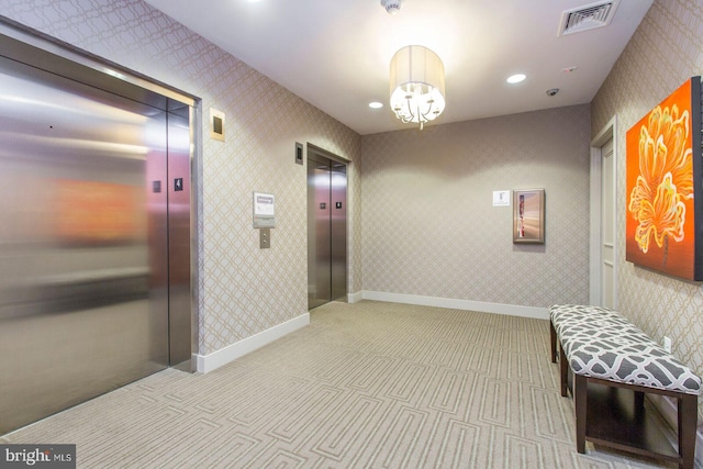hall featuring elevator, visible vents, wallpapered walls, and carpet floors