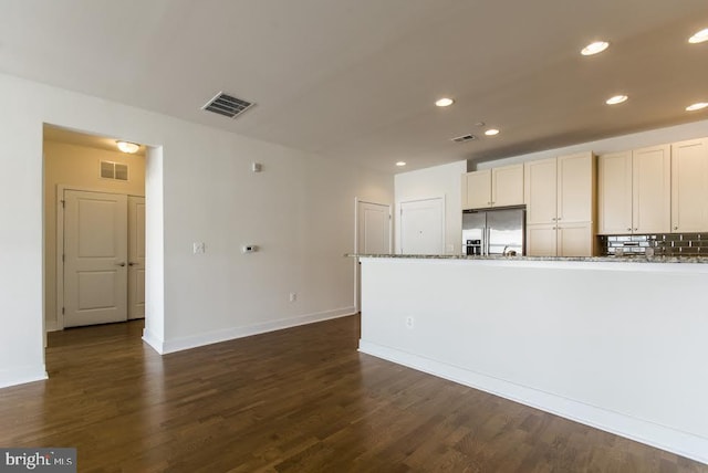 kitchen featuring stainless steel fridge with ice dispenser, visible vents, and dark wood-style floors