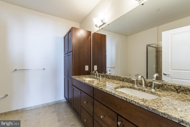 bathroom featuring double vanity, toilet, a shower stall, and a sink