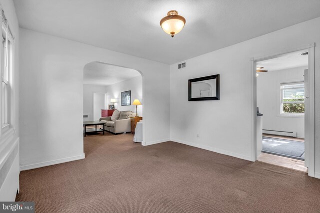 1545 Maple Ave, Haddon Heights, NJ 08035 - living area with baseboard heating, arched walkways, carpet, and baseboards