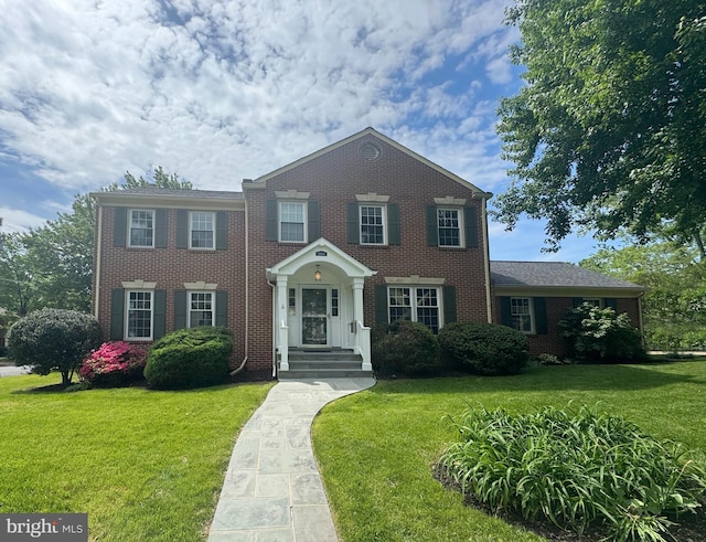 view of front of house with brick siding and a front lawn